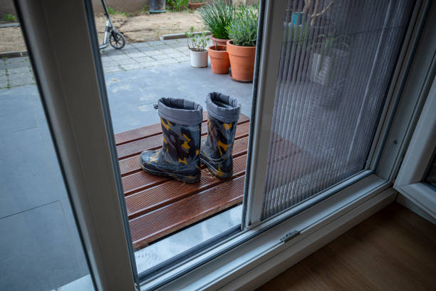 istock Dirty boots in front of a mosquito wire door. 1317182430
