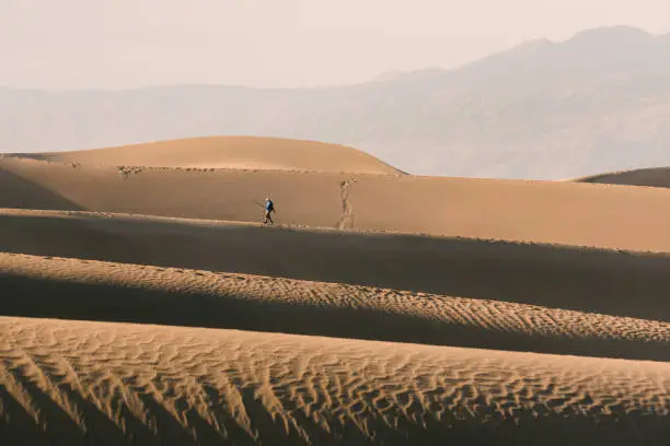 Photo of Hiking in desert. Mesquite Flat Sand Dunes in Death Valley National Park and silhouette of walking man