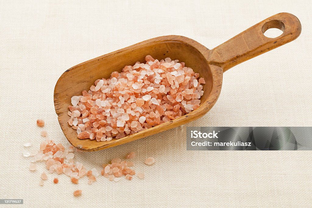 Himalayan salt scoop coarse crystals of pink and orange Himalayn salt on rustic wooden scoop Canvas Fabric Stock Photo