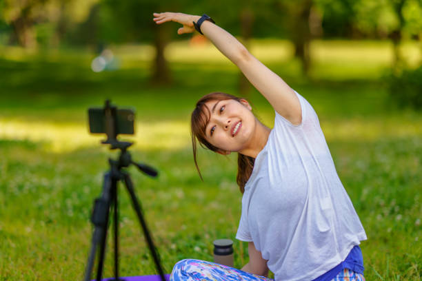 istock Female yoga instructor teaching online in nature 1317199173