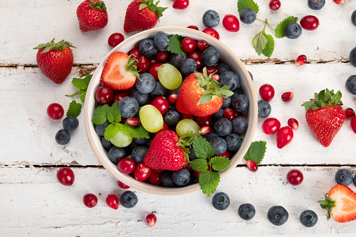 Various fresh forest berries on white background. Organic food concept. Top view