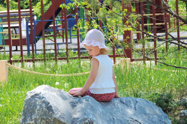 Young woman needs help and stretches her hand from rocky hole