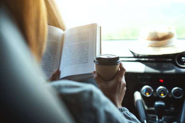 istock A woman reading book and drinking coffee in the car 1317200020