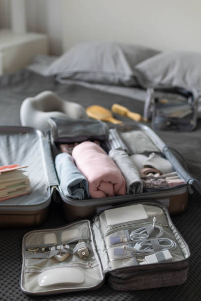 istock Suitcase technique wires equipment on bed. Package or storage with stuff, clothes and accessories 1317205869
