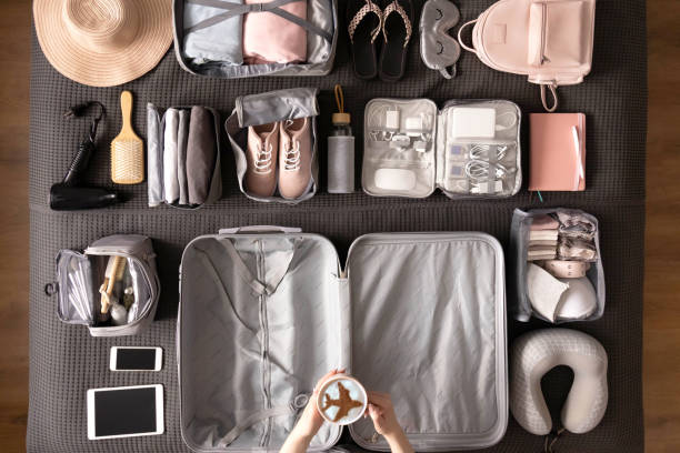 istock Top view woman hands getting ready to travel vacation packing suitcase use konmari method 1317206746