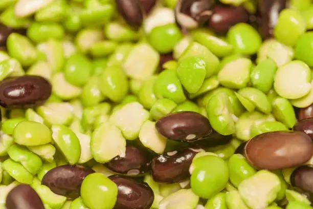 Photo of Soaked and swollen dark beans and green peas for cooking a vegetarian dish.