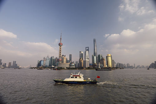 Shanghai, China - 12 01 2017: The Police ship boat near The Bund waterfront Shanghai China. The Bund is a waterfront area view to Shanghai China modern skyscrapers skyline urban city.