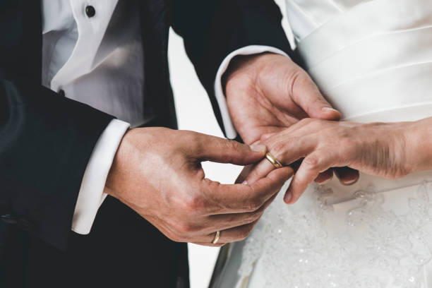 istock Midsection Of Couple Exchanging Wedding Ring 1317209659