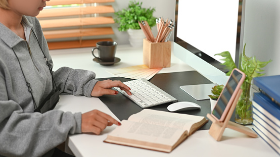 Cropped shot of businesswoman working on computer at home office.