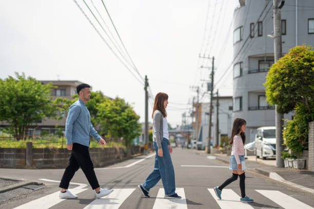 Family walking in residential district Family walking around neighborhood zebra crossing photos stock pictures, royalty-free photos & images