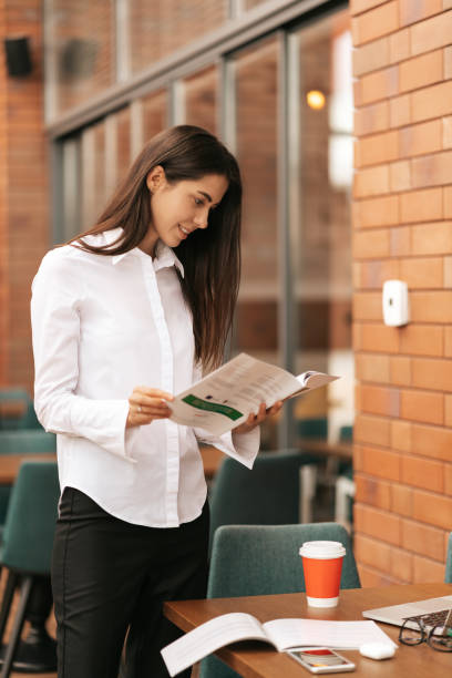 istock Businesswoman working while standing at table and smiling 1317212928