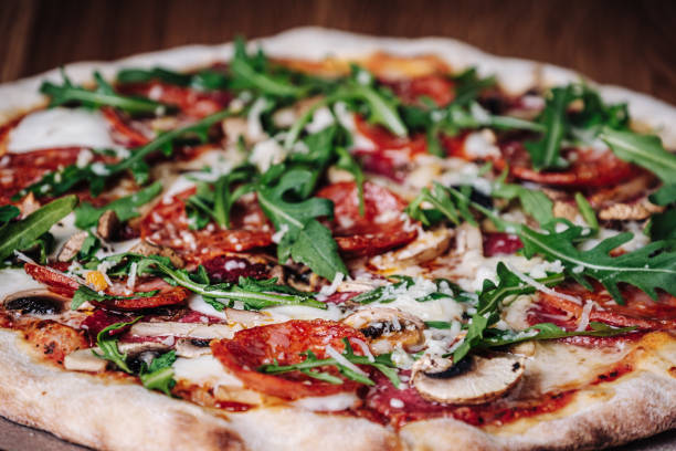 istock Appetizing Pizza on a Wooden Board in a Restaurant 1317214758