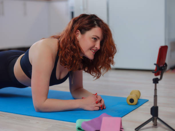 istock Fit Young Woman Excersising At Home, Watching Video Tutorial On smartphone 1317216552