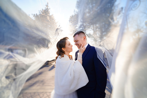 gentle and romantic bride and groom under the veil. happy and loving newlyweds. newlyweds on their wedding day