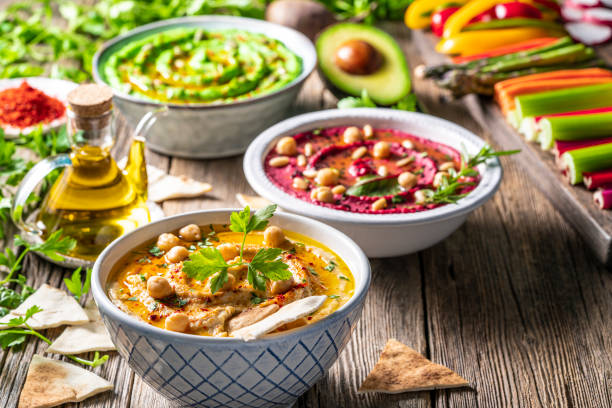 istock Hummus Three bowl of chickpeas, avocado and beetroot vegetables for dip on rustic wooden table 1317217905
