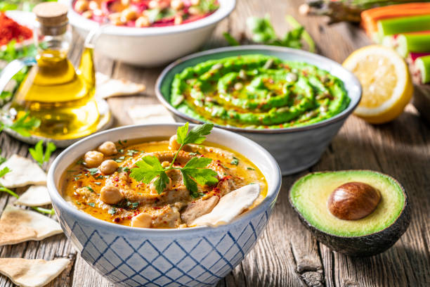 istock Hummus Three bowl of chickpeas, avocado and beetroot vegetables for dip on rustic wooden table 1317217917