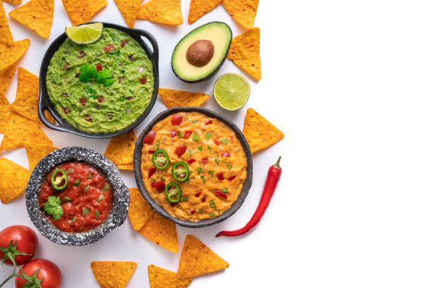 Mexican dip sauces guacamole, cheedar dip and tomato salsa with Nacho chips isolated on white with copy space