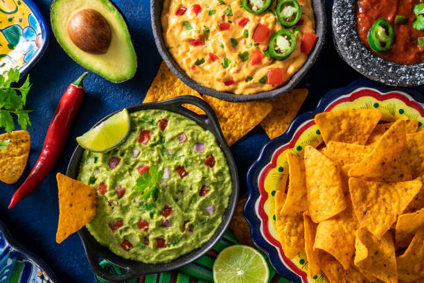 istock Mexican dip sauces guacamole, cheedar dip, tomato salsa and pico de gallo with Nacho chips 1317219521