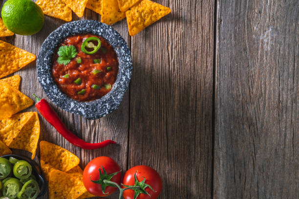 istock Mexican tomato salsa dip sauce with Nacho chips and chili on a rustic wooden table 1317219581