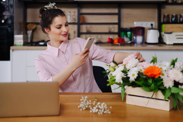 istock Young florist looking at laptop and answering phone call 1317219627