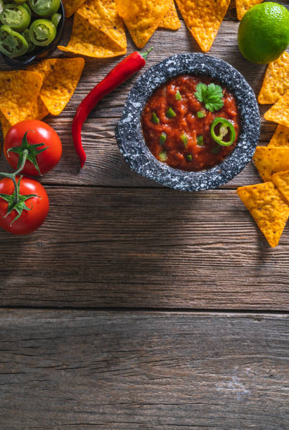 istock Mexican tomato salsa dip sauce with Nacho chips and chili on a rustic wooden table 1317219649