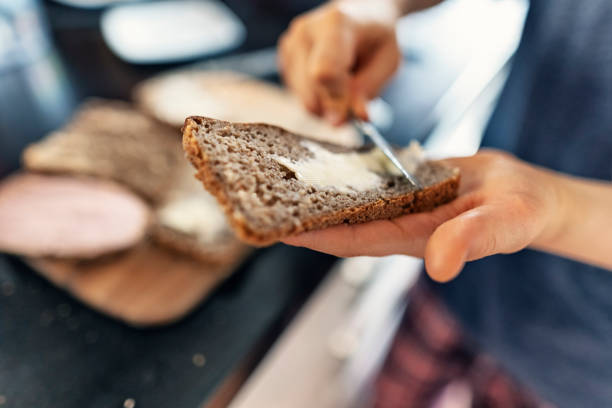 nastoletni chłopiec pomaga przygotować śniadanie w słoneczny poranek - polish bread zdjęcia i obrazy z banku zdjęć