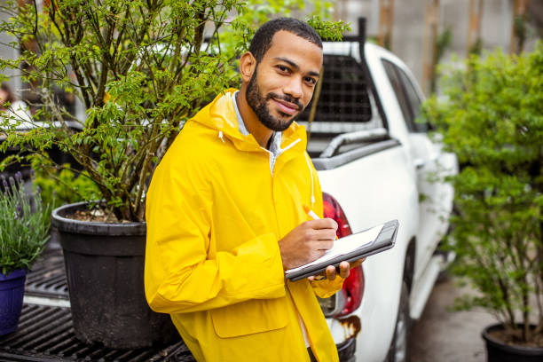 garden center worker transporting plants - horticulture imagens e fotografias de stock