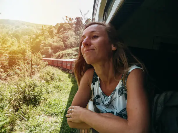 Traveling young woman  Girl enjoying train ride in tea plantations