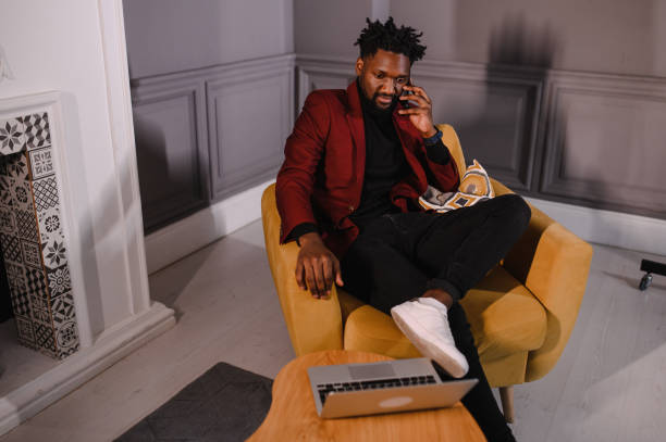 istock Smiling millennial african american casual man working with apps or communicating online on laptop 1317225319