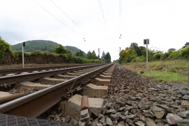 Railroad tracks and railroad ties leading straight to a far distance