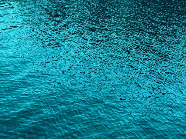 istock Turquoise shiny background. Glittering glossy blue sea water. 1317232997