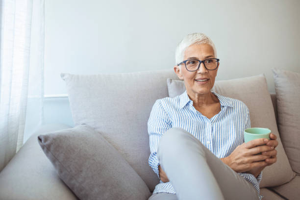 istock Beautiful 50 years old caucasian lady sit down on the sofa 1317234776