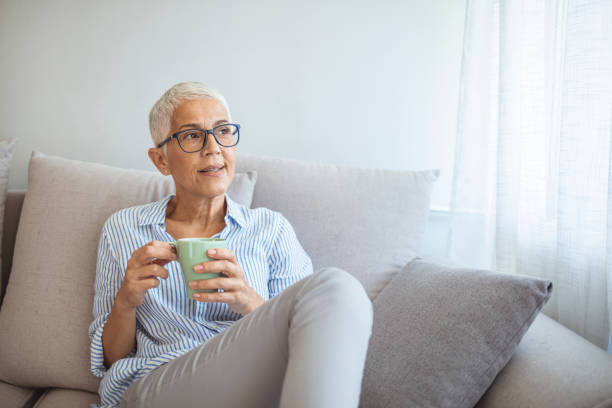 istock Beautiful 50 years old caucasian lady sit down on the sofa 1317234954