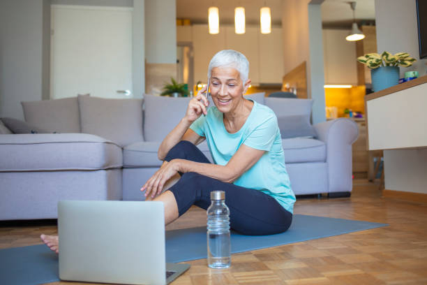 istock Senior woman using smartphone at home after exercise. 1317235129