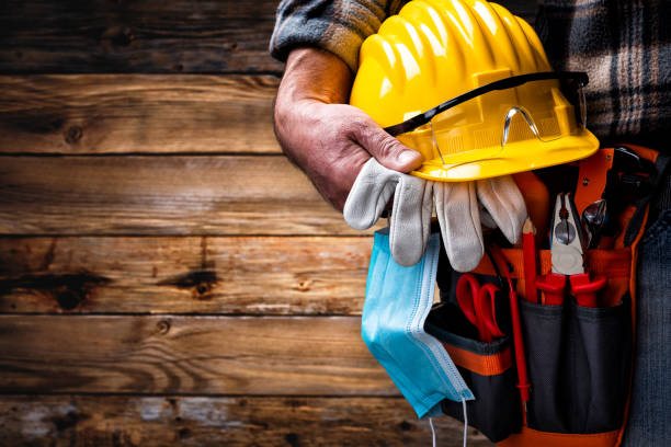 istock Electrician technician with tool belt and surgical mask on rustic wooden background. Electricity. Covid-19 prevention. 1317236695