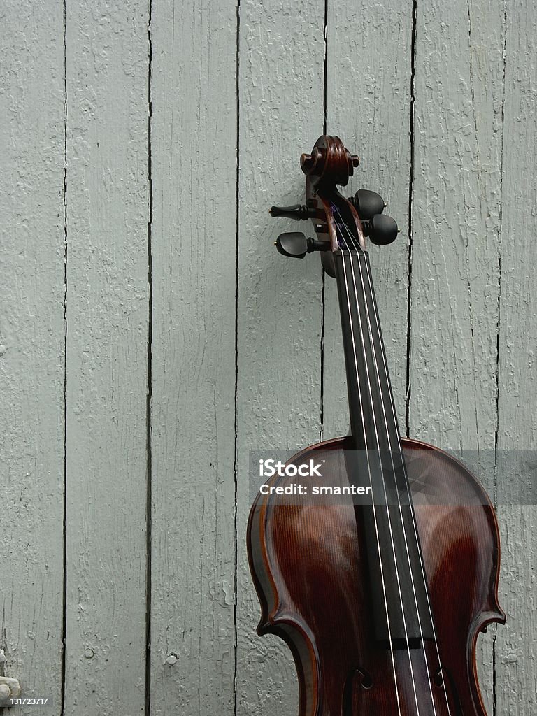 Fiddle with board background Fiddle leaning against a white wood wall. Musical Instrument Stock Photo