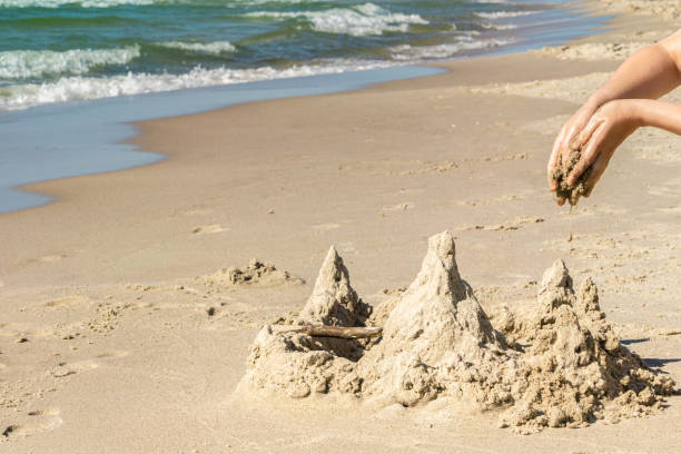 istock Hands building sand castle at beach sunny day in summertime 1317237309
