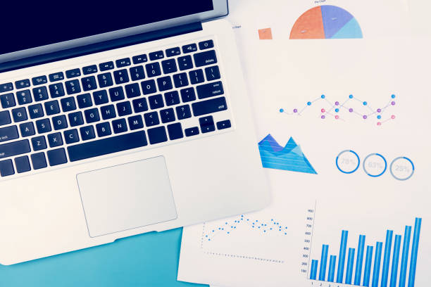 istock Laptop computer and documents report statistic financial with graph and chart on desk office, finance and invest, digital marketing and growth of revenue, business and communication concept. 1317240439