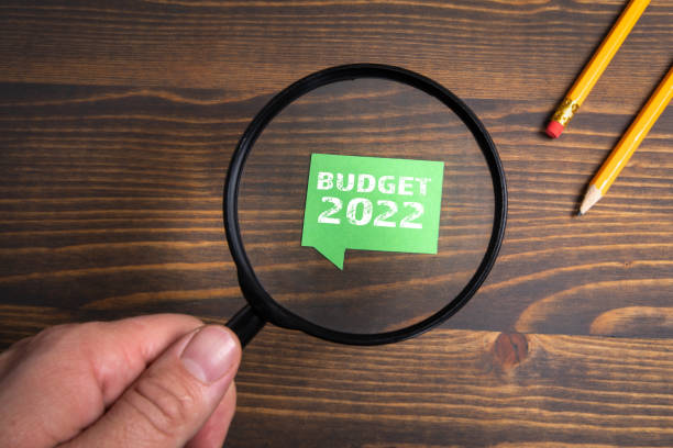 istock Budget for 2022. Speech bubble and magnifying glass on a wooden background 1317240516