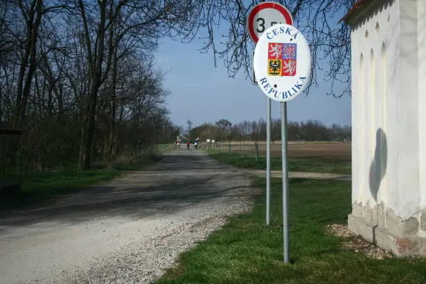 "n"nPicture of a border roadsign on a road in Czech republic with the czech coat of arms, it indicates the nearby presence of the border between Austria and Czech Republic, both countries of the European union and the Schengen Zone.