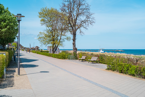 Usedom Island, Mecklenburg Western Pomerania, Germany - May 9, 2021: Beach promenade in Heringsdorf with trees and a view of the Baltic Sea on the island of Usedom.