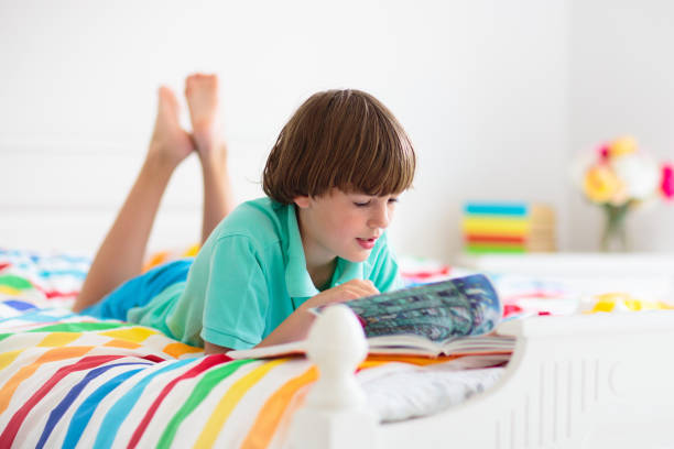 istock Child reading in bed. Kids read. Boy at home. 1317246736
