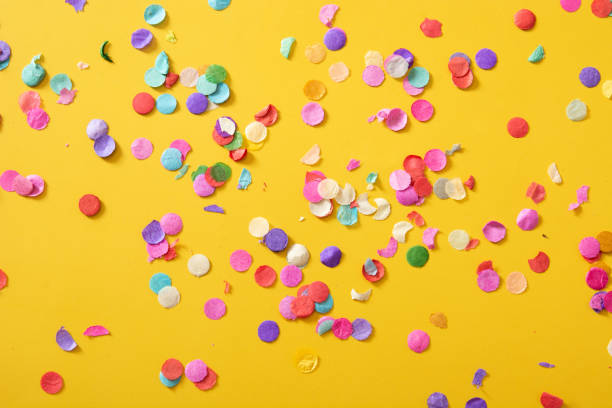 istock Colorful confetti on yellow background 1317248340