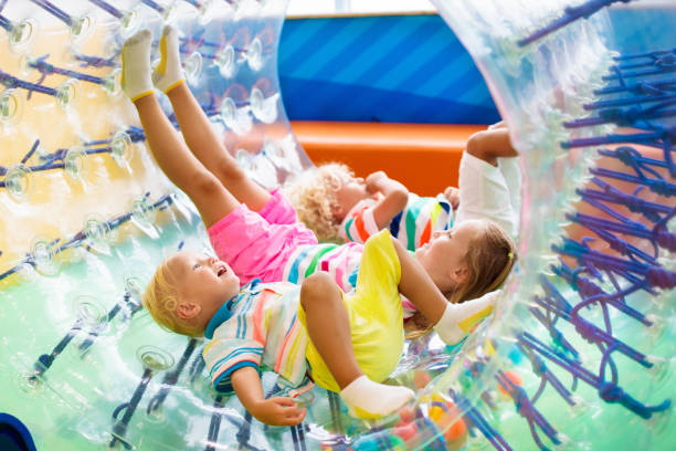 niño juega en rueda de rodillos. niños en trampolín. - inflatable child playground leisure games fotografías e imágenes de stock