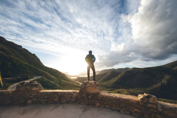 Man standing on the wall looking at beautiful mountain landscape in Cartagena, province of Murcia, Spain.