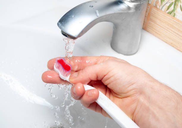istock A man's hand washes a toothbrush under the tap 1317254266