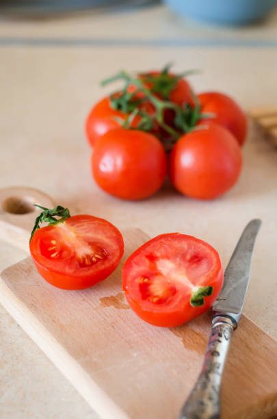 istock Fresh sliced tomatoes on cutting board on a table. 1317257428