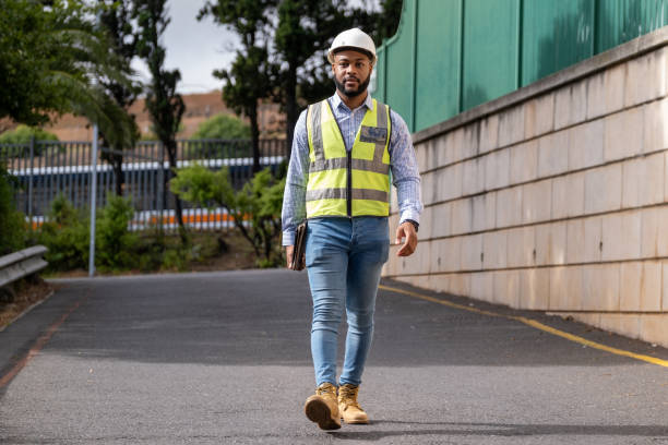 istock African Engineer walking near a construction site with protective gear 1317258491