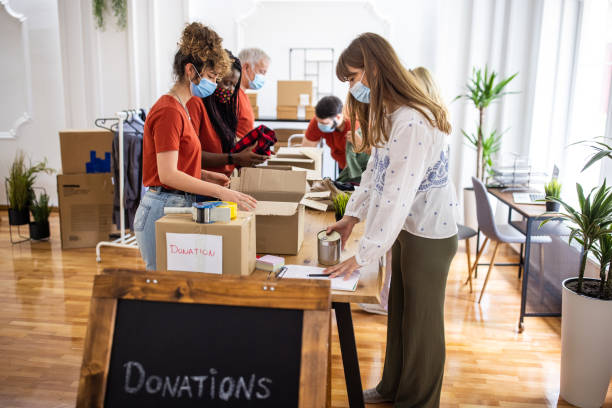 istock Volunteers taking donations from people at charitable donation center during coronavirus pandemic 1317259383