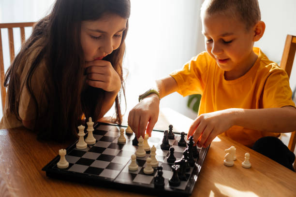 istock Smiling Sibling Playing Chess At Home 1317260434